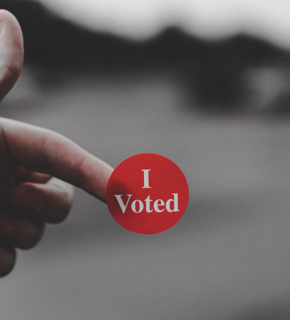 Photo of a red circular badge saying I voted.